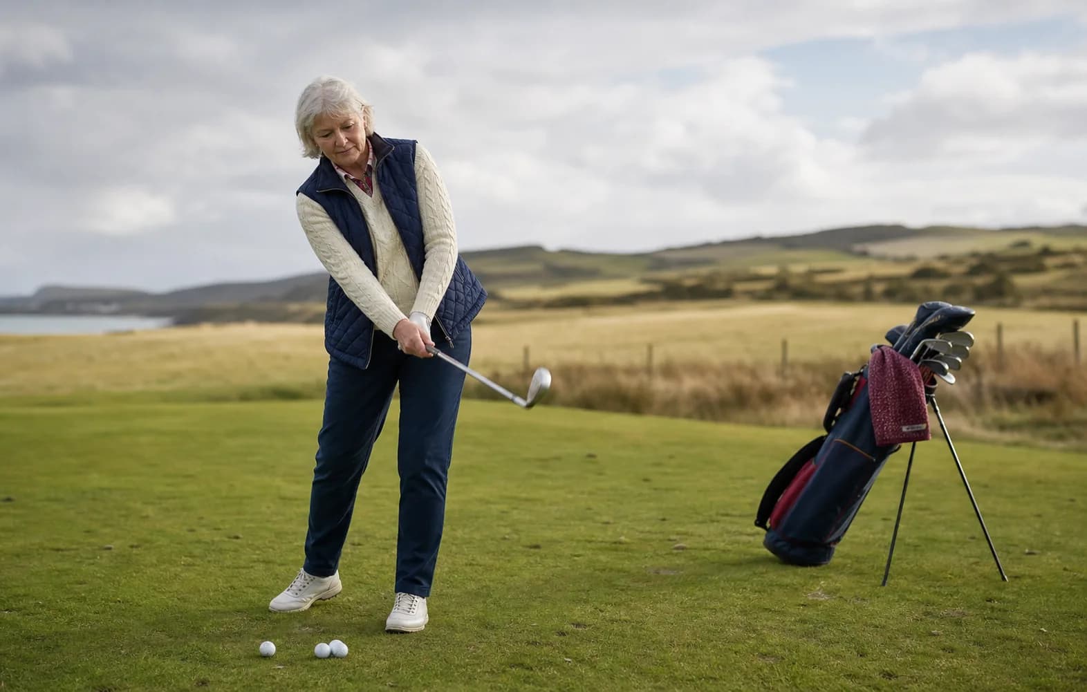 A woman in her sixties learning a short golf swing outdoors