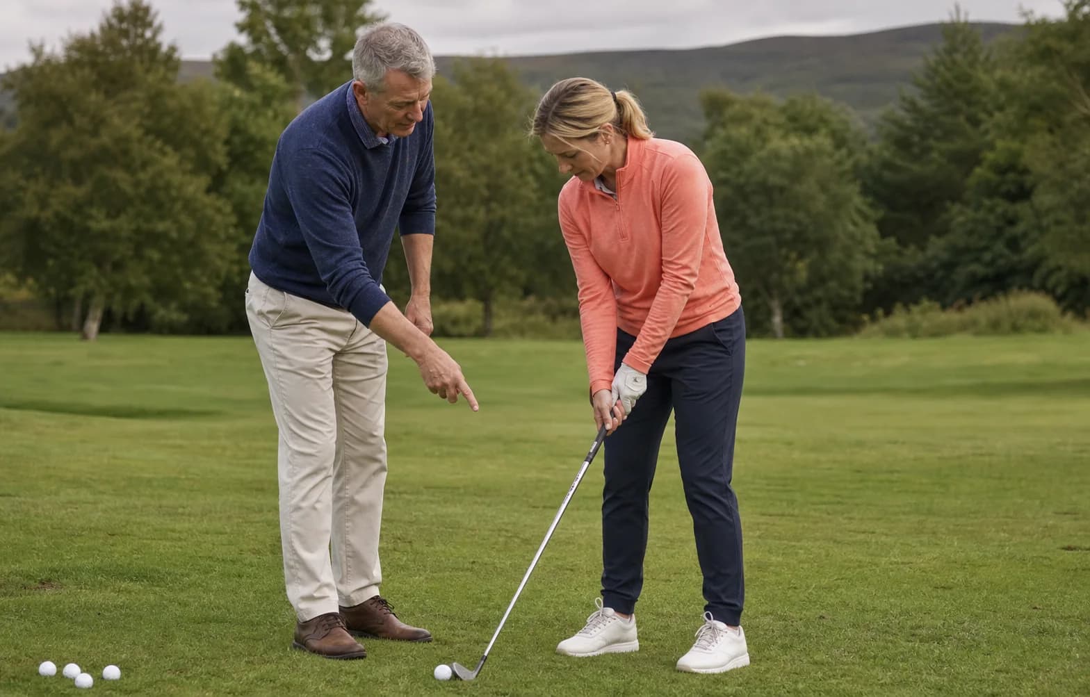 A coach and golfer examining club alignment during a one-to-one lesson